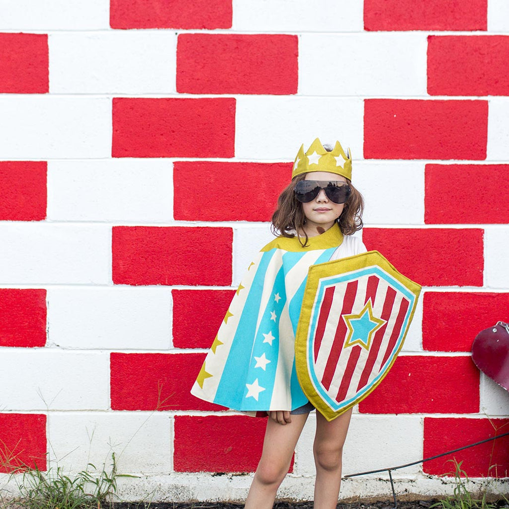 Child Superhero Costume in Action Blue Stripe Cape against wall